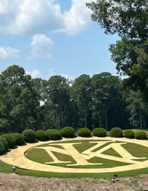 A large circular floral arrangement with the letters 'MSU' in the center, surrounded by greenery.